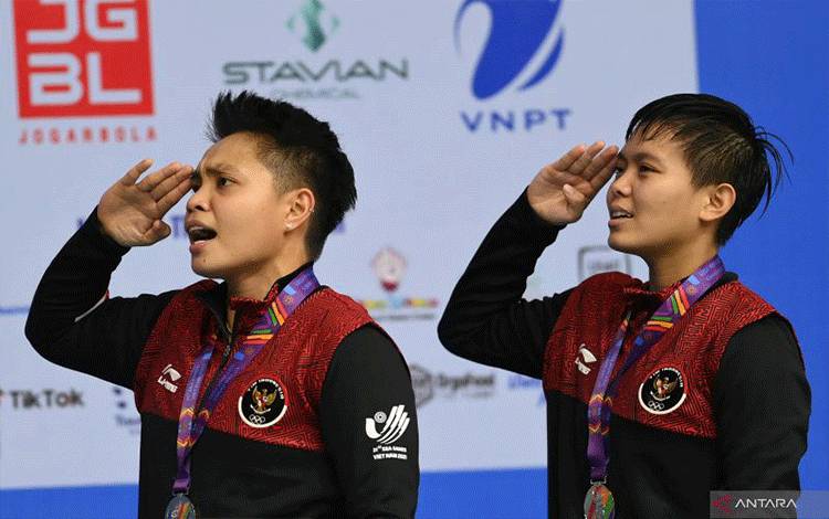 Pebulu tangkis ganda putri Indonesia Apriyani Rahayu (kiri) dan Siti Fadia Silva Ramadhanti (kanan) memberikan hormat ke bendera Merah Putih saat Upacara Penghormatan Pemenang final bulu tangkis ganda putri SEA Games 2021 Vietnam di Bac Giang Gymnasium, Vietnam, Minggu (22/5/2022). ANTARA FOTO/Zabur Karuru/wsj. (ANTARA FOTO/ZABUR KARURU)