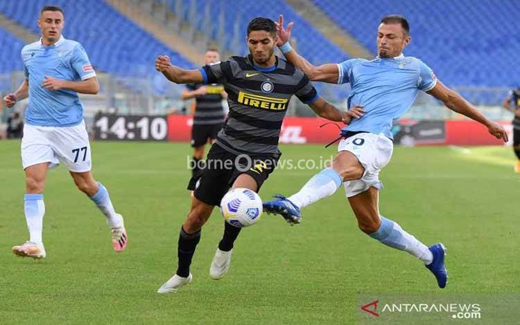 Pemain Lazio Stefan Radu berebut bola dengan pemain Inter Milan Achraf Hakimi pada pertandingan Liga Italia Serie A di Stadion Olimpico, Roma, Minggu (4/10/2020). Kedua tim bermain imbang 1-1