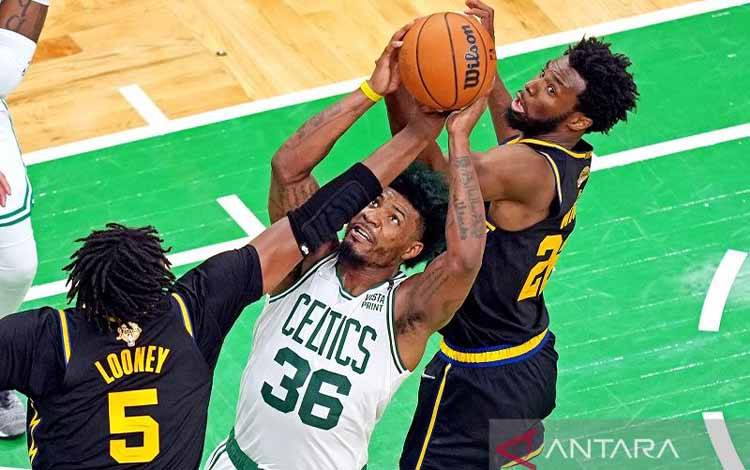 Pebasket Boston Celtics Marcus Smart (tengah) berebut bola rebound dengan dua pemain Golden State Warriors Kevon Looney (kiri) dan Andrew Wiggins dalam Gim 4 Final NBA di TD Garden, Massachusetts, Amerika Serikat, Jumat (10/6/2022) waktu setempat. (ANTARA/REUTERS/USA TODAY SPORTS/Kyle Terada)