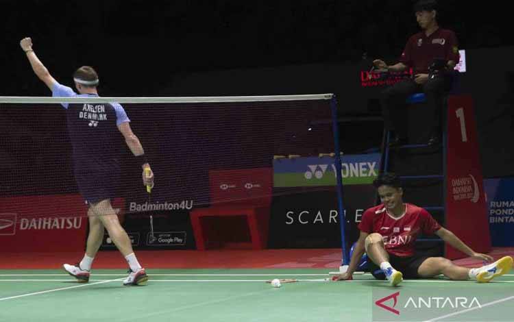 Pebulu tangkis tunggal putra Indonesia Anthony Sinisuka Ginting (kanan) terduduk usai gagal mengembalikan kok ke pebulu tangkis Denmark Viktor Axelsen pada babak Semi Final Daihatsu Indonesia Masters 2022 di Istora Senayan, Jakarta, Sabtu (11/6/2022). Langkah Anthony Ginting ke babak Final terhenti usai kalah dengan skor 15-21 dan 15-21