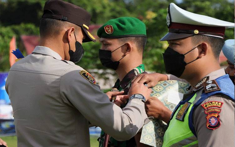 Kapolres Lamandau AKBP Arif Budi Purnomo menyematkan pita atau tanda pada salah satu anggota dalam Operasi Patuh Telabang 2022 saat apel Gabungan di Mapolres Lamandau.