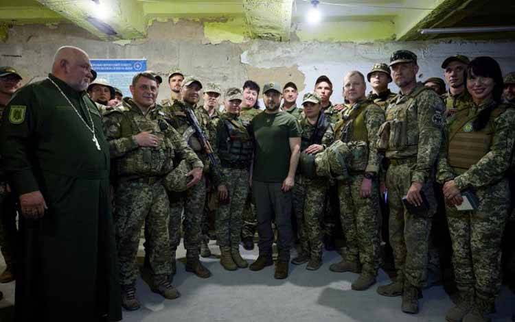 Presiden Ukraina Volodymyr Zelenskiy berpose untuk foto bersama dengan prajurit Ukraina di sebuah titik saat serangan Rusia terhadap Ukraina berlanjut di luar kota selatan Mykolaiv, Ukraina, Sabtu (18/6/2022)