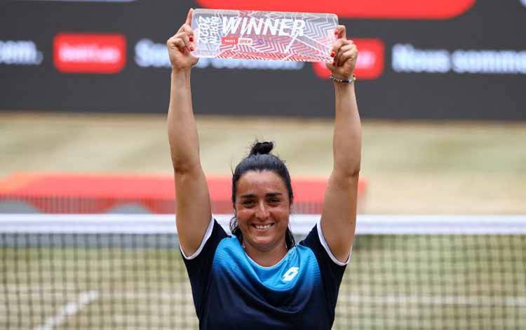 Petenis Tunisia Ons Jabeur mengangkat trofi Berlin Open setelah mengalahkan petenis Swiss Belinda Bencic dalam final di Berlin, Jerman, 19 Juni 2022. (REUTERS/CHRISTIAN MANG)