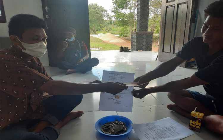 Kedua warga yang berselisih menunjukan surat pernyataan perdamaian