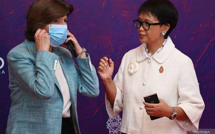 Menteri Luar Negeri Retno Marsudi (kanan) meminta Menteri Luar Negeri Prancis Catherine Colonna melepas masker untuk berfoto bersama setibanya di tempat Pertemuan Menteri Luar Negeri (FMM) G20 di Nusa Dua, Bali, Jumat (8/7/2022). (ANTARA FOTO/Nyoman Budhiana/rwa)