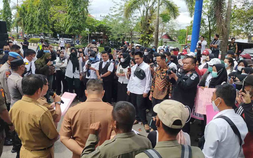 Asisten I Setda Kotim Diana Setiawan saat menemui bekas tenaga kontrak yang melakukan aksi demo di depan Kantor Pemkab Kotim. (FOTO : HAMIM)