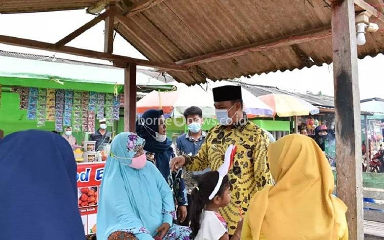 Bupati Lamandau Hendra Lesmana berbincang dengan sejumlah pelaku UMKM di Pasar Induk Nanga Bulik. (FOTO : HENDI NURFALAH)