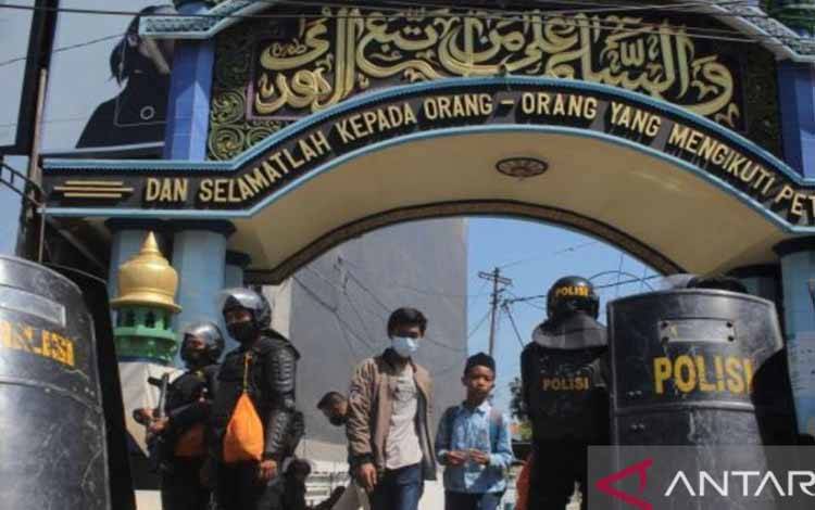 Polisi berjaga di depan gerbang Pondok Pesantren Shiddiqiyyah Ploso selama proses penangkapan Moch Subchi Azal Tsani (MSAT), orang yang diduga melakukan kekerasan seksual kepada santri, di Kabupaten Jombang, Jawa Timur, Kamis (7/7/2022). (ANTARA/Syaiful Arif)