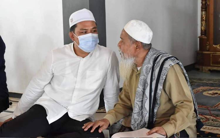Bupati Lamandau Hendra Lesmana berbincang dengan salah satu tokoh agama saat menggelar acara safari Jumat. (FOTO : HENDI NURFALAH)