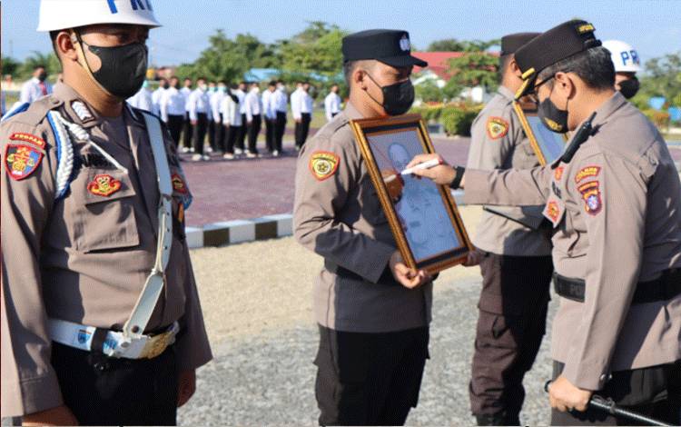 Kapolres Katingan AKBP Paulus Sonny Bhakti Wibowo memberi tanda silang pada gambar personelnya yang dipecat pada upacara PTDH di halaman Mapolres Katingan, Kamis,? 21 Juli 2022. (FOTO: GOPUR)