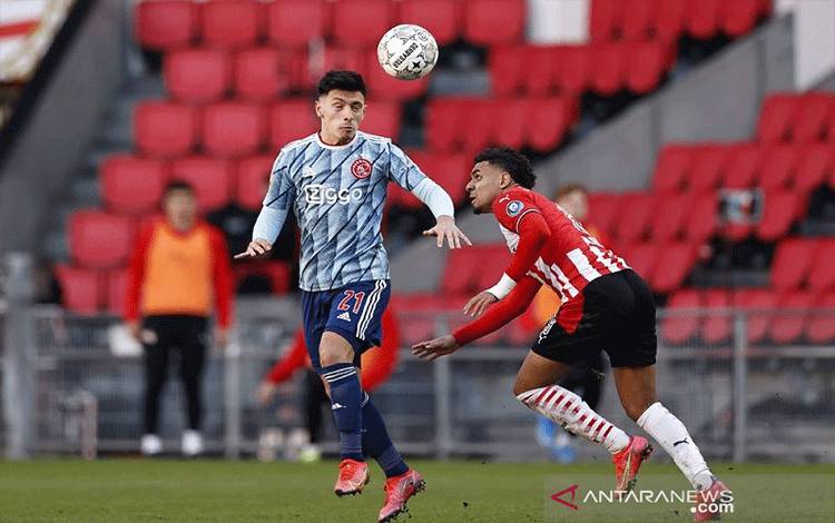 Foto arsip - Bek Ajax Lisandro Martinez (kiri) berebut penguasaan bola dengan penyerang PSV Eindhoven Donyell Malen dalam lanjutan Liga Belanda di Stadion Johan Cruijff Arena, Amsterdam, Belanda, Minggu (28/2/2021). (ANTARA/AFP/ANP/Maurice van Steen)