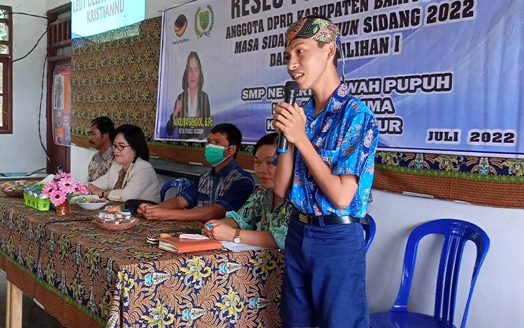 Siswa SMP Negeri 2 Benua Lima bernama Anugerah Kristiannu menyanyikan Tumet Leut saat menyambut kunjungan reses anggota DPRD Barito Timur dari Partai Nasdem Adolina Sendol, Kamis, 28 Juli 2022. (FOTO: BOLE MALO)
