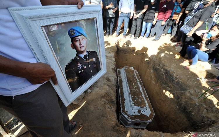 Kerabat memegang foto almarhum Brigadir Nofriansyah Yoshua Hutabarat atau Brigadir J saat pemakaman kembali jenazah setelah autopsi ulang di Sungai Bahar, Muarojambi, Jambi, Rabu (27/7/2022). Autopsi ulang yang berlangsung selama enam jam itu dilakukan atas permintaan keluarga dalam mencari keadilan dan pengungkapan kasus. ANTARA FOTO/Wahdi Septiawan/hp.