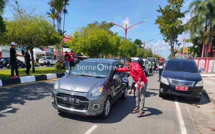 Ketua DPRD Palangka Raya Bagikan Bendera Merah Putih di Jalan