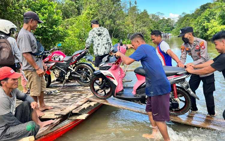Anggota Polsek Katingan Tengah Bantu Warga Lintasi Banjir