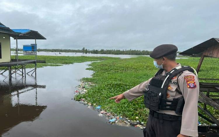 Anggota Satsamapta Polresta Palangka Raya saat memantau kondisi debit air di Jalan Mendawai ujung Kota Palangka Raya. (FOTO: AGUS)