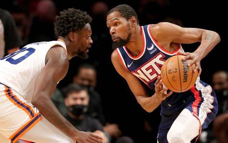 Forward Brooklyn Nets Kevin Durant (kanan) dihadang forward New York Knicks Julius Randle (30) dalam pertandingan NBA kedua tim di Barclays Center, Brooklyn, New York, Amerika Serikat, pada 30 November 2021 (ANTARA/REUTERS/USA TODAY Sports/Brad Penner)