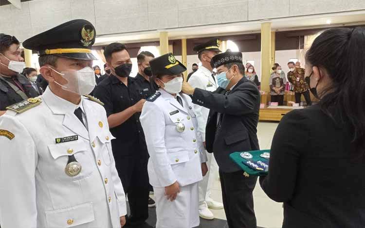 Bupati Barito Timur Ampera AY Mebas menyematkan atribut kepada para camat saat acara pelantikan pengambilan sumpah/janji 130 pejabat di lingkungan Pemkab Barito Timur yang terdiri dari pejabat pimpinan tinggi pratama, pejabat administrator, pejabat pengawas dan pejabat fungsional tertentu, Jumat, 26 Agustus 2022. (FOTO: BOLE MALO)