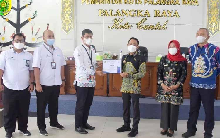 Wali Kota Palangka Raya, Fairid Naparin menerima piagam penghargaan kategori debitur peringkat ketiga nasional. (FOTO: HUMAS PEMKO)