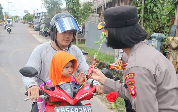 Polwan Polres Lamandau Bagikan Bunga dan Coklat ke Pengendara