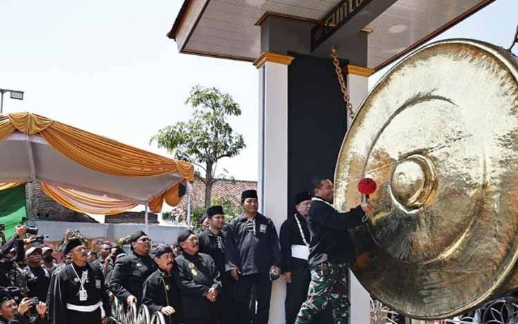 Panglima TNI Jenderal Andika Perkasa memukul gong monumen satu abad PSHT emas dalam acara puncak peringatan satu abad perguruan pencak silat tersebut di Gedung Graha Krida Budaya Padepokan PSHT, Kota Madiun, Jawa Timur, Jumat (2-9-2022). ANTARA/HO-Diskominfo Kota Madiun