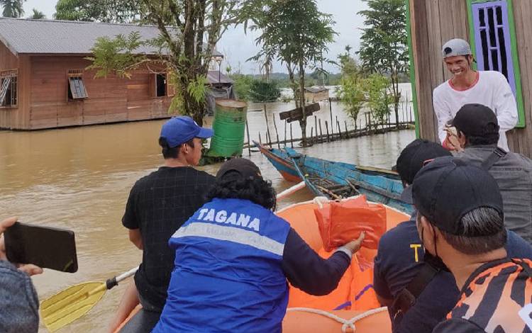 Tim gabungan sedang membagikan makanan siap saji kepada warga terdampak banjir di Kelurahan Tampang Tumbang Anjir, Kecamatan Kurun, Kabupaten Gunung Mas pada Senin, 5 September 2022. (FOTO: BPBD GUMAS)