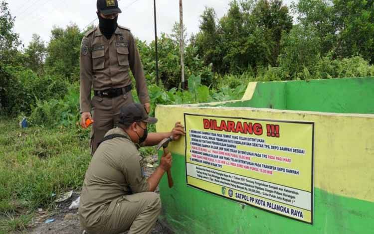 Satpol PP Palangka Raya saat memasang spanduk di sejumlah TPS. (FOTO: SATPOL PP)