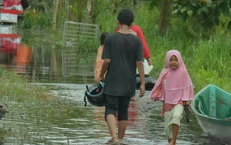 Kondisi aktifitas warga yang mulai terganggu akibat banjir yang sudah merendam permukiman mereka.(Foto : Agus Fataroni M)