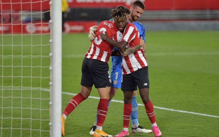 Foto arsip - Kiper Athletic Bilbao Unai Simon (belakang, bek Unai Nunez dan striker Nico Williams (kanan) merayakan gol mereka dalam laga Sevilla melawan Athletic Bilbao di Stadion Ramon Sanchez Pizjuan di Seville pada 3 Mei 2021. Nico Williams menjadi pencetak salah satu dari tiga gol Bilbao kala menang 3-2 atas Rayo Vallecano pada 17 September 2022. (AFP/CRISTINA QUICLER)