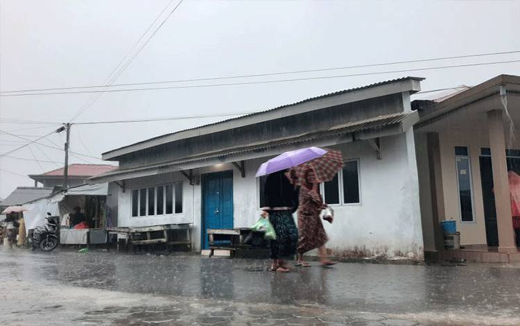Warga menggunakan payung di tengah hujan melanda Tanjungpinang, Kepri. (Ogen)