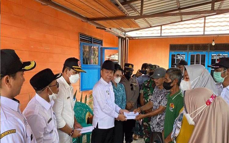 Bupati Kapuas saat menyerahkan bantuan kepada warga terdampak musibah kebakaran rumah di Desa Saka Mangkahai, Rabu, 28 September 2022. (FOTO: BPBD KAPUAS)?