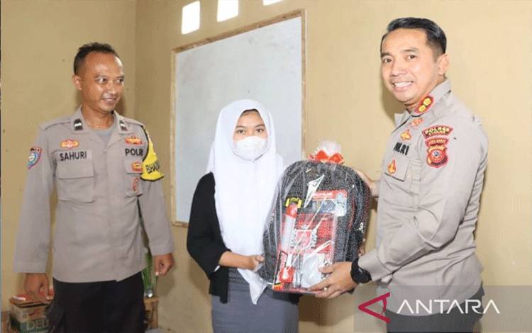 Kapolres Cianjur, Jawa Barat, AKBP Doni Hermawan, memberikan bantuan untuk siswa didampingi Aipda Sopyan Sahuri yang mendirikan rumah belajar untuk anak putus sekolah di Kecamatan Cugenang. (ANTARA/Ahmad Fikri)