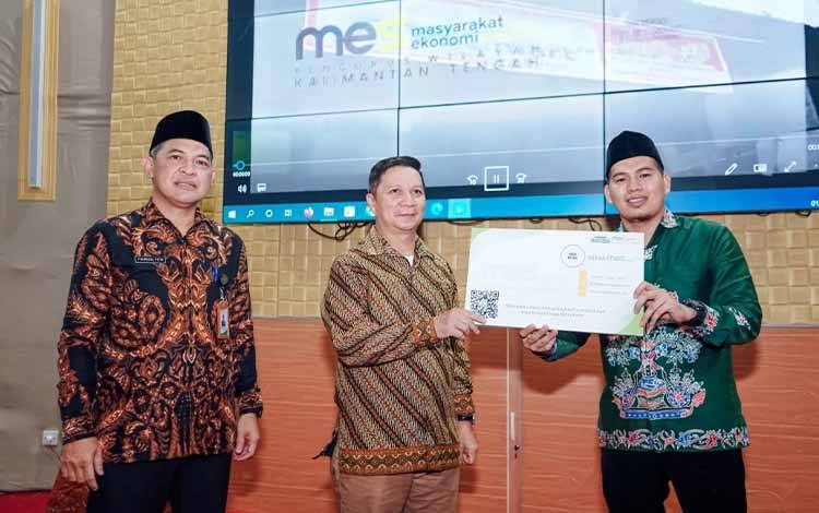 Penyerahan kartu mitra MES Mart oleh Ketua Koperasi MES Falah Hapakat, Fathan Asy'ari (kanan) kepada Staff Ahli Gubernur Kalteng, Suhaemi (tengah) didampingi Ketua Umum MES Kalteng, Fahrizal Fitri (kiri) di Aula Asmaul Husna IAIN, Sabtu, 1 November 2022. (FOTO: HERMAWAN)