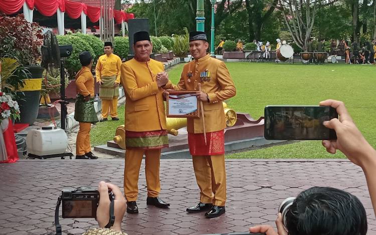 Pj. Bupati Kobar Anang Dirjo menyerahkan piagam penghargaan pada Kapolres Kobar AKBP Bayu Wicaksono usai upacara peringatan HUT ke 63 Kobar, Senin, 3 Oktober 2022