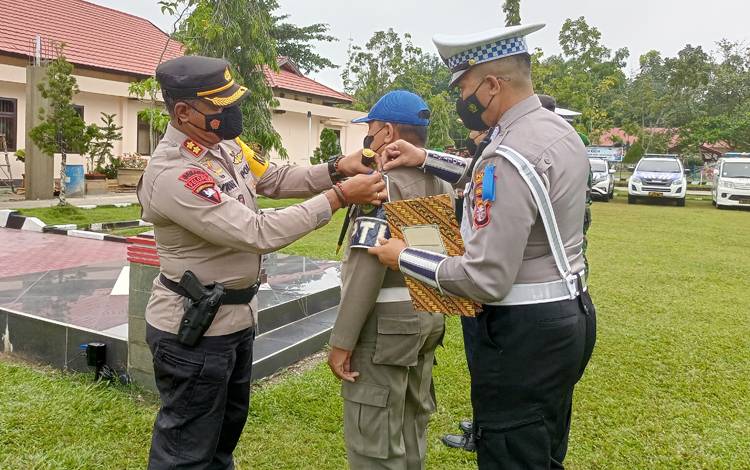Kapolres Barito Timur menyempatkan pita tanda Operasi Zebra Telabang 2022 kepada personel Satpol PP yang akan terlibat dalam kegiatan tersebut. (FOTO: BOLE MALO)