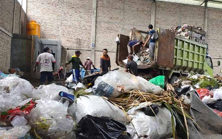 Proses pengangkutan sampah dari depo ke dalam truk oleh petugas. (FOTO: NISA)