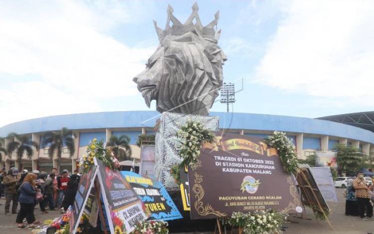 Warga berdoa di patung Singa Tegar kawasan Stadion Kanjuruhan yang dipenuhi karangan bunga di Malang, Jawa Timur, Senin (3/10/2022). Pasca kerusuhan pada pertandingan Arema FC melawan Persebaya sejumlah karangan bunga dari berbagai kalangan terus berdatangan di tempat tersebut sebagai ungkapan duka cita atas banyaknya korban jiwa. ANTARA FOTO/Prasetia Fauzani/hp.