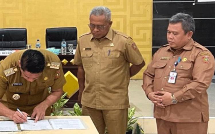 Pj. Bupati Kobar Anang Dirjo saat menandatangani SK penggantian jabatan Sekda Kobar yang sebelumnya dijabat oleh Suyanto (tengah) dan digantikan oleh Plt. Sekda Juni Gultom (kanan)