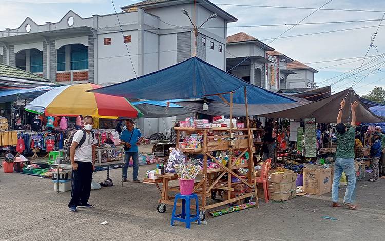 Kepala UPT Pasar Temanggoeng Djaja Karti Tamiang Layang, Marjuno (kaos putih) mengawasi pedagang pasar tungging yang menata barang jualan, Minggu, 16 Oktober 2022. (FOTO: BOLE MALO)