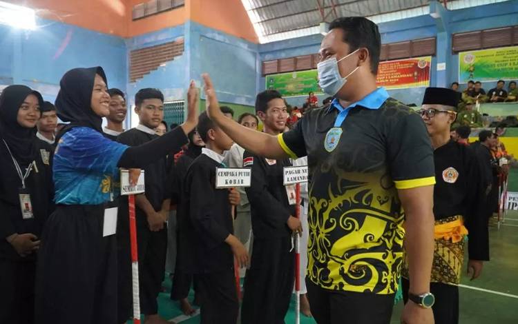 Bupati Lamandau Hendra Lesmana menyalami sejumlah pesilat peserta kejuaraan Bupati CUP I Lamandau. (FOTO: HENDI)