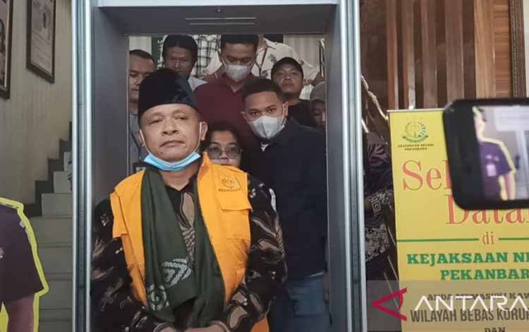 Mantan Rektor UIN Sultan Syarif Kasim Riau Akhmad Mujahidin saat keluar dari kantor Kejari Pekanbaru, Jumat, untuk menjalani penahanan. (ANTARA/Annisa Firdausi)