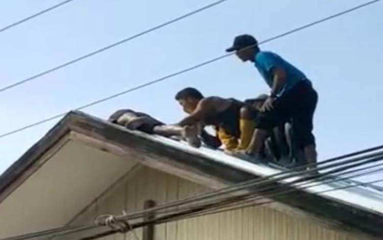 Warga Samba Danum mengevakuasi salah seorang warga yang terkena strum listrik di salah satu arap rumah, Selasa, 25 Oktober 2022