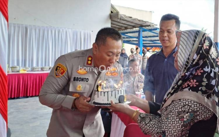 Kapolres Lamandau AKBP Bronto Budiyono meniup lilin di kue ulang tahun yang diberikan PWI Kabupaten Lamandau. (FOTO : ISTIMEWA)