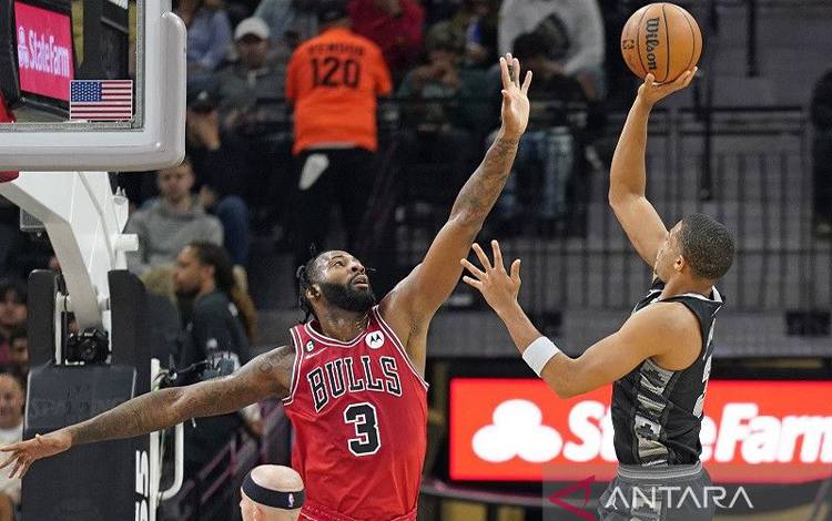 Pebasket San Antonio Spurs Keldon Johnson (kanan) berusaha mencetak angka di hadapan pemain Chicago Bulls Andre Drummond dalam lanjutan NBA di AT&T Center, Texas, Amerika Serikat, Jumat (28/10/2022) waktu setempat. (ANTARA/REUTERS/USA TODAY SPORTS/Scott Watcher)