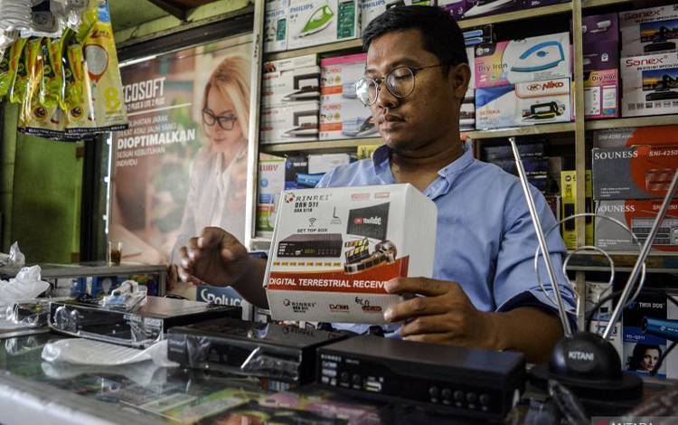 Seorang pramuniaga mengecek dekoder televisi atau set top box (STB) yang dijual di salah satu toko elektronik di Tangerang Selatan, Banten, Jumat (28/10/2022). Kominfo akan menghentikan siaran televisi analog atau Analog Switch Off (ASO) di Jabodetabek pada 2 November 2022. ANTARA FOTO/Sulthony Hasanuddin/aww. (ANTARA FOTO/SULTHONY HASANUDDIN)