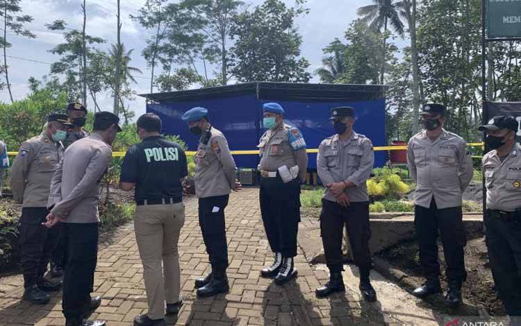 Polisi berjaga di lokasi autopsi di TPU Dusun Patuk, Desa Sukolilo, Kecamatan Wajak, Kabupaten Malang, Jawa Timur, Sabtu (5/11/2022). (ANTARA/Vicki Febrianto)