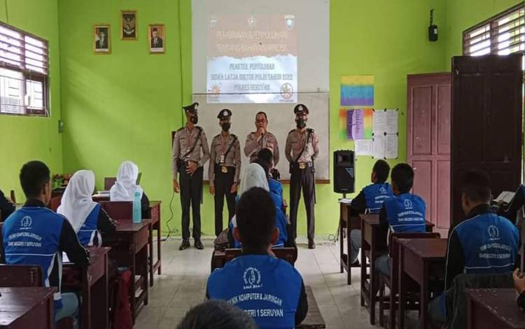 Kasat Binmas Polres Seruyan Iptu Eko Muji Hartono bersama siswa SPN Polda Kalteng, memberikan sosialisasi kepada pelajar SMK Negeri 1 Seruyan ( Foto: Polres Seruyan)