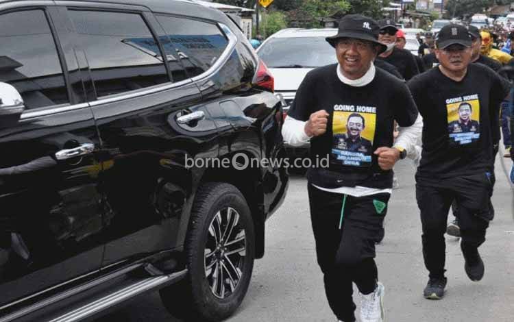 Bupati Cilacap Tatto Suwarto Pamuji (depan) berlari kecil dalam perjalanan memenuhi nazar berjalan kaki dari rumah dinas menuju kediaman pribadi di Desa Ciguling, Kecamatan Majenang, Cilacap, Senin (14-11-2022), menjelang berakhirnya masa jabatannya sebagai kepala daerah setempat. ANTARA/HO-Dinkominfo Cilacap