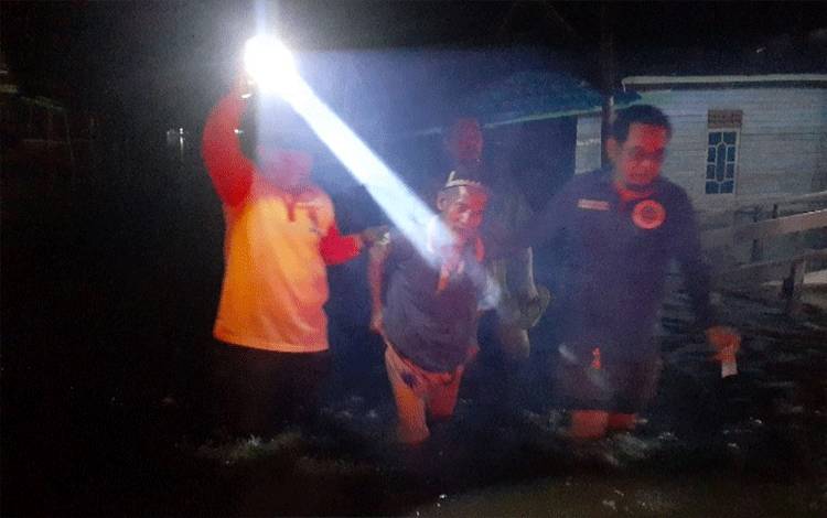Proses evakuasi kakek Basuni dari kediamannya di Jalan Anoi yang sudah teredam parah.?(Foto : Agus Fataroni M)
