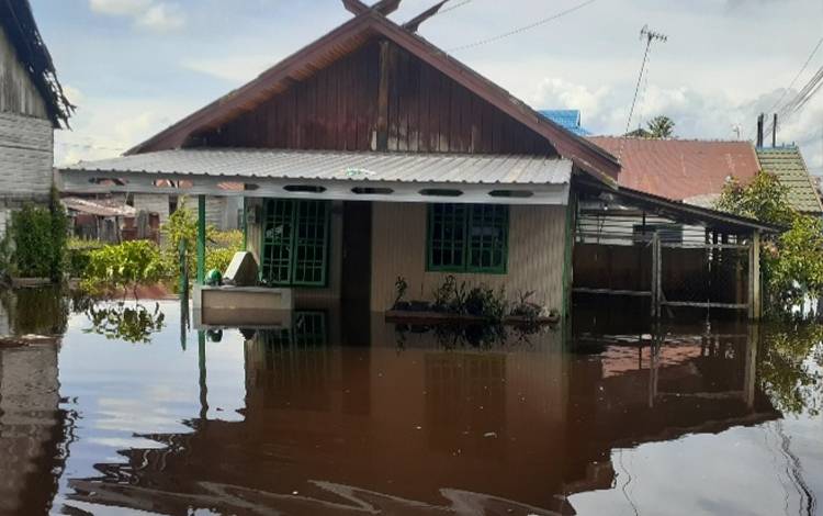 Salah satu rumah yang sudah di padamkan aliran listriknya lantaran sudah terendam banjir. (FOTO: AGUS FATARONI M)